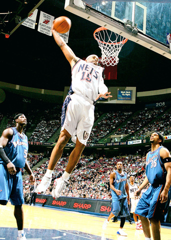 The New Jersey Nets player Vince Carter goes and hits a huge dunk