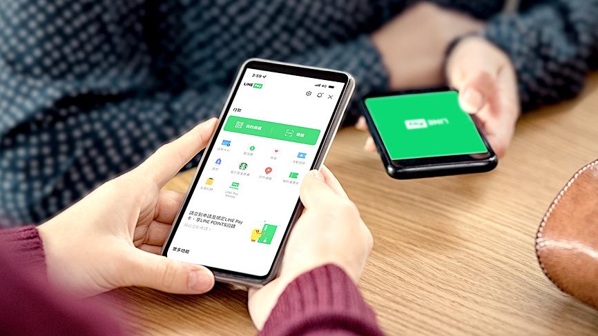 Image of a person holding a phone with LINE Pay app open, about to pay.