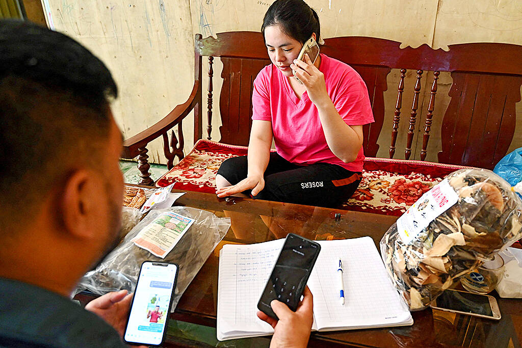  TikToker and farmer Luong Quang Dai left, and his wife in October check orders of the goods they sell on Dai’s TikTok channel at their house in Bac Kan province. Photo AFP  