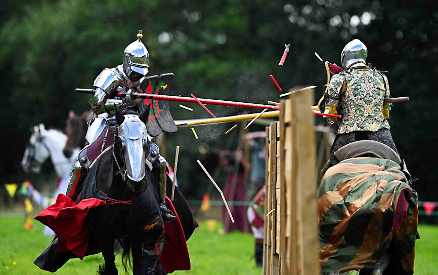 Two knights in armor fighting a duel with lances in a